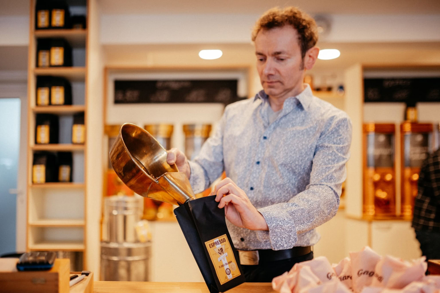 Kaffeebohnen tropfen. - photoart hübner business Mann inspiziert Kaffee in stilvollem Geschäft.