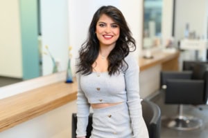 Moderne Businessfotografie für Personal Branding und Karriere - photoart hübner business Frau in professionellem Outfit vor einem modernen Bürohintergrund, lächelnd und selbstbewusst.