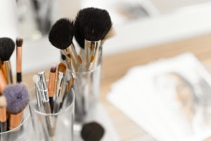 Make-up Pinsel und Kosmetikpinsel auf einem Tisch - photoart hübner business Pinsel für Make-up und Kosmetik in einem Glas, Nahaufnahme.