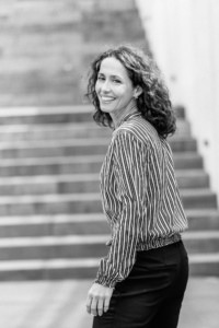 Moderne Businessfrau vor Treppen - photoart hübner business Frau in Businesskleidung steht vor Treppen, lächelt in die Kamera.