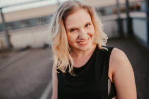 Porträt einer jungen Frau in Businesskleidung auf einem Dach, professionelle Unternehmensfotografie. - photoart hübner business Porträt einer jungen Frau mit freundlichem Lächeln, ideal für Personal Branding und Karrierefotos.