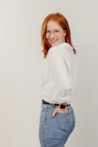 Businessfotografie Portrait einer jungen Frau mit rotem Haar und Brille - photoart hübner business Porträt einer Frau in Businesskleidung für professionelle Personal Branding Fotos.
