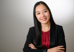 Unternehmensporträt einer jungen Frau in Businesskleidung - photoart hübner business Junge asiatische Geschäftsfrau in Businesskleidung, lächelnd.