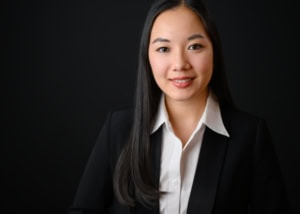 Unternehmensfotografin im Businessoutfit - photoart hübner business Porträt einer professionellen Frau in Businesskleidung vor dunklem Hintergrund.