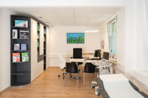 Arztpraxis mit moderner Einrichtung, Behandlungsraum, Computer und Behandlungsstuhl für Patienten.