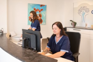 Arzthelferinnen am Empfang im medizinischen Büro, professionell und freundlich.