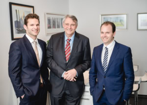 Geschäftsleute bei Business-Meeting in moderner Büroatmosphäre - photoart hübner business Drei Geschäftsleute in Anzügen bei einem Meeting im Büro.