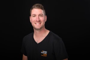 Businessporträt eines Mannes - photoart hübner business Freundliches Businessfoto eines Mannes vor schwarzem Hintergrund.