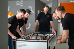 Fußballspiel im Büro - photoart hübner business Mitarbeiter spielen Tischfußball im modernen Büro.