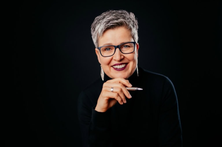 Frau mit Brille und grauem Haar, lächelnd, vor schwarzem Hintergrund - photoart hübner business Frau mit Brille und grauem Haar, lächelnd, vor schwarzem Hintergrund, professionell und freundlich.