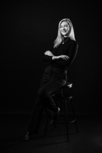 Professionelles Business-Portrait einer jungen Frau in Schwarz-Weiß.