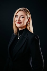 Professionelles Business-Porträt einer Frau in schwarzem Anzug.