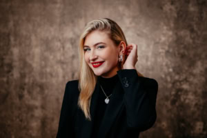 Selbstbewusste Business-Frau in schwarzem Blazer, professionelles Porträt.