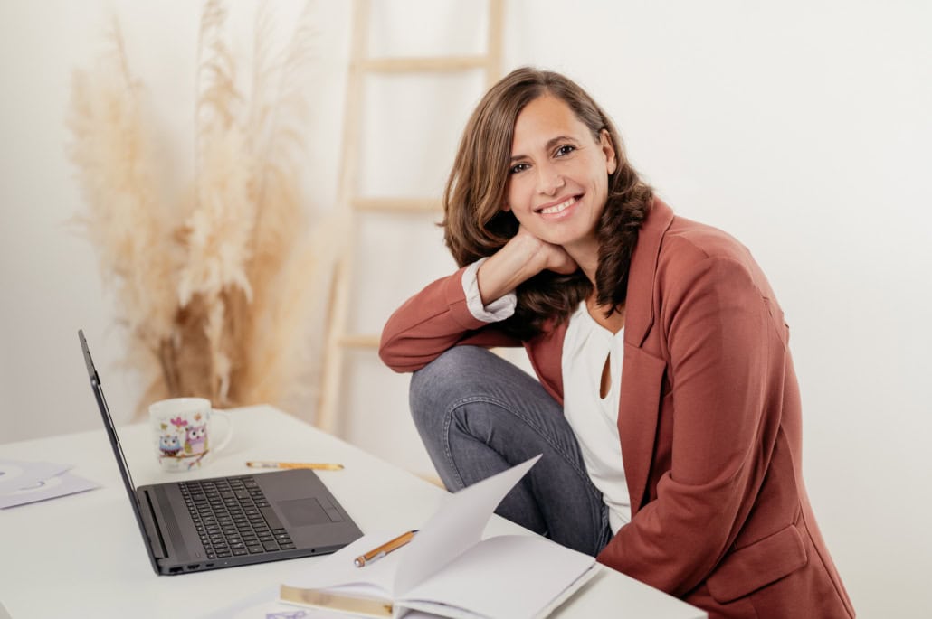 Moderne Business-Frau bei der Arbeit im Homeoffice - photoart hübner business Business-Frau arbeitet an Laptop im Homeoffice, freundlich und professionell.