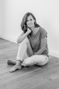 Moderne Businessfotografie für Personal Branding und Karriere. - photoart hübner business Frau sitzt entspannt auf Holzboden, professionelle Businessfotografie.