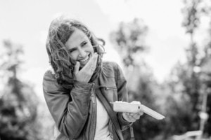 Lächelnde Frau im Freien mit Notizblock - photoart hübner business Lächelnde Frau bei Businessfotografie im Freien, perfekt für Personal Branding und Karrierefotos.