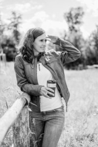 Businessfrau bei Outdoor-Porträt, professionelle Personal Branding Fotos. - photoart hübner business Frau in Lederjacke blickt in die Ferne, hält Kaffee to-go, im Freien.