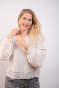 Fotografie einer lachenden Frau mit blondem Haar, die professionell posiert. - photoart hübner business Lachende Frau mit blondem Haar, professionell posiert, für Business- und Portraitfotografie.