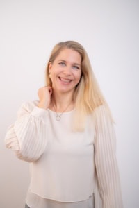 Businessfotografie Portrait einer lächelnden Frau - photoart hübner business Frau mit freundlichem Lächeln, professionell gekleidet, vor neutralem Hintergrund.