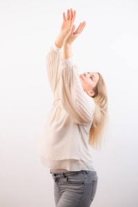 Businessporträt mit natürlichem Ausdruck und professionellem Look - photoart hübner business Frau in Businesskleidung hebt die Hände in einem modernen Fotoshooting.