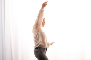 Moderne Businessfotografie mit natürlichem Licht - photoart hübner business Frau in Businesskleidung posiert vor hellem Hintergrund, professionelles Fotoshooting.