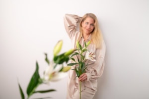 Moderne Businessfotografie mit Blumenmotiv - photoart hübner business Frau hält weiße Lilien, professionelles Businessfoto für Personal Branding.