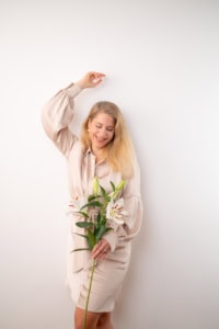 Fröhliche Frau mit Blumen vor weißem Hintergrund - photoart hübner business Glückliche Frau hält Blumen und posiert für Business- oder Personal Branding Fotos.