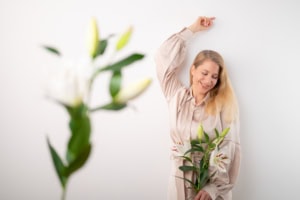 Businessfotografie mit natürlichem Ausdruck und professionellem Ambiente - photoart hübner business Frau mit Blumen für Business- und Personal Branding Fotos, authentisch und sympathisch.