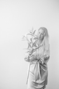 Porträt einer Frau mit Pflanze, Businessfotografie, professionelles Personal Branding. - photoart hübner business Porträt einer lächelnden Frau, die eine Pflanze hält, geeignet für Unternehmens- und Karrierefotos.