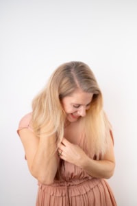 Hübsche junge Frau in rosa Kleid, lächelnd, auf weißem Hintergrund. - photoart hübner business Schöne junge Frau in rosa Kleid, lächelnd, vor weißem Hintergrund.