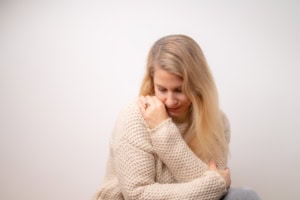 Hübsche junge Frau in gemütlichem Pullover, nachdenklich und entspannt - photoart hübner business Junge Frau in Pullover, nachdenklich und entspannt, auf weißem Hintergrund.