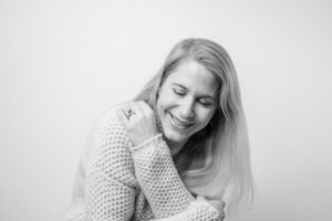 Moderne Businessporträtfotografie in Schwarz-Weiß - photoart hübner business Lächelnde Frau bei professionellem Businessfoto, monochrom, freundliche Ausstrahlung.