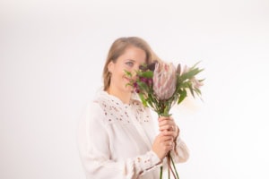 Businessfotografie Portrait mit Blumen - photoart hübner business Frau hält Blumenstrauß, professionelles Businessfoto für Personal Branding.