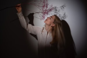 Moderne Businessfotografie mit natürlichem Ausdruck - photoart hübner business Porträt einer Frau mit Blumen, ideal für Personal Branding und Karrierefotos.