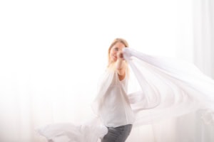 Businessfotografie mit natürlichem Licht und professionellem Look - photoart hübner business Frau posiert mit weißem Tuch vor hellem Hintergrund, Business- und Personal Branding Fotos.