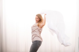 Businessfotografie mit lebendiger Persönlichkeit und natürlichem Ausdruck - photoart hübner business Frau posiert mit Tuch vor weißem Hintergrund, professionelle Businessfotografie.