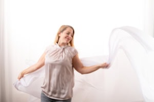 Selbstbewusste Frau mit Stoff im Studio - photoart hübner business Frau posiert professionell für Business- und Personal Branding Fotos.