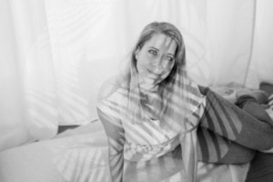 Businessporträt einer Frau in natürlichem Licht - photoart hübner business Frau sitzt entspannt auf einem Bett, ideal für professionelle Business- und Personal Branding Fotos.