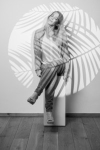 Frau posiert kreativ vor Schattenwurf - photoart hübner business Frau in Businesskleidung vor einer Wand mit Schatten von Blättern, kreative Unternehmens- und Person.