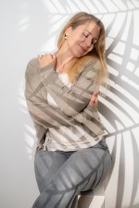 Selbstbewusstes Porträt einer Frau mit Schattenmuster - photoart hübner business Frau posiert für Businessfotografie, Schattenmuster auf weißem Hintergrund.