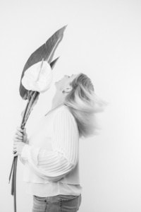 Businessfotografie Portrait mit Blumen - photoart hübner business Frau hält große Blume, professionelles Businessfoto, Personal Branding.