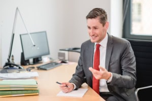 Professionelles Porträt eines Mannes im Büro - photoart hübner business Geschäftsmann im Anzug bei einem Meeting im modernen Büro.