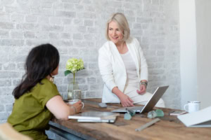 Zwei Frauen im Gespräch bei Business-Meeting, moderne Büroumgebung.