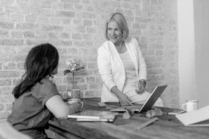 Geschäftliche Beratung zwischen Frau und Kundin im modernen Büro.