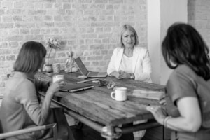 Businessberatung im Meetingraum mit Frauen, die an einem Tisch sitzen.
