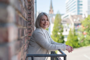 Business-Portrait einer Frau mit Stadtblick, ideal für professionelle Präsentationen.