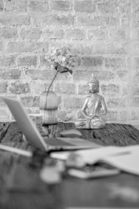 Arbeitsplatz mit Buddha und Blumen, perfekt für Business- und Kreativfotografie.