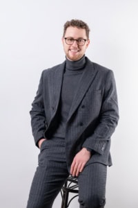 Businessporträt mit Mann in Anzug, Businessfotografie, professionelles Personal Branding - photoart hübner business Mann in Businesskleidung sitzt auf einem Stuhl, lächelt freundlich, ideal für Karriere- und Unterneh.