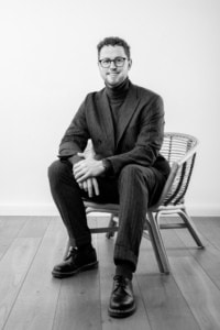 Businessfotografie Portrait eines Mannes in Businesskleidung - photoart hübner business Mann in Businesskleidung sitzt entspannt auf einem Stuhl, professionelles Businessfoto.