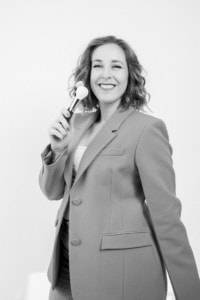 Businessfotografie Portrait einer Frau mit Pinsel, professionelles Business-Image, Personal Branding, Karrierefotos. - photoart hübner business Frau in Businesskleidung lächelt in die Kamera, symbolisiert Selbstbewusstsein und Erfolg.